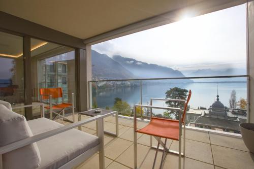 a bedroom with a balcony with a view of the mountains at Montreux Lake View Apartments and Spa - Swiss Hotel Apartments in Montreux