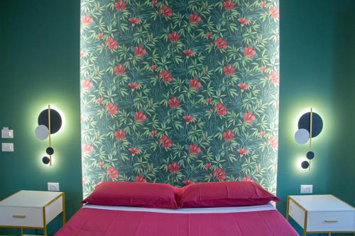a bedroom with a pink bed with a floral wallpaper at WANDERLUST SPACCANAPOLI Points Of View in Naples