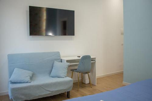 a bedroom with a couch and a desk with a chair at WANDERLUST SPACCANAPOLI Points Of View in Naples