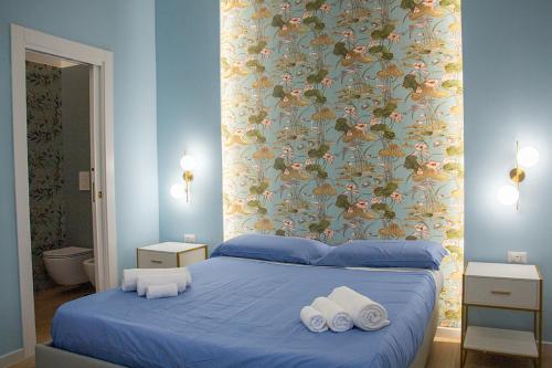 a bedroom with a blue bed with towels on it at WANDERLUST SPACCANAPOLI Points Of View in Naples