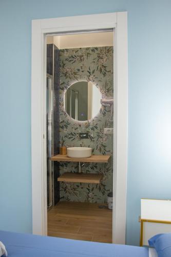 a bathroom with a sink and a mirror at WANDERLUST SPACCANAPOLI Points Of View in Naples