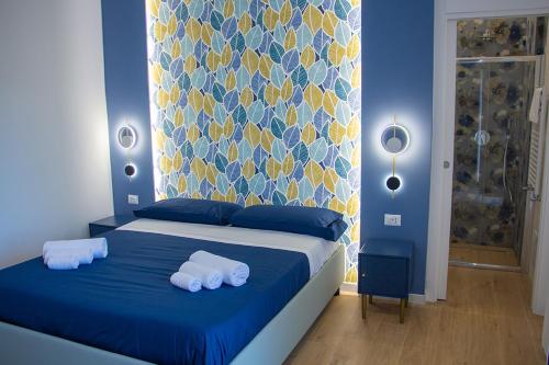 a blue bedroom with a bed with towels on it at WANDERLUST SPACCANAPOLI Points Of View in Naples
