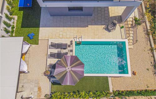 an overhead view of a pool with an umbrella and chairs at Beautiful Home In Zaboric in Zaboric
