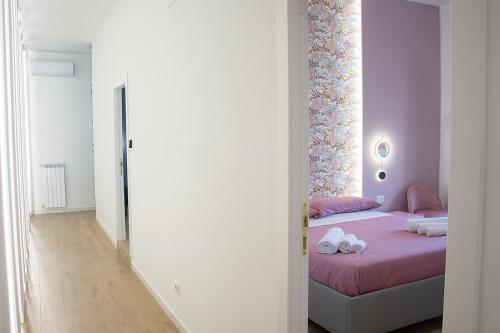 a bedroom with a pink bed with towels on it at WANDERLUST SPACCANAPOLI Points Of View in Naples