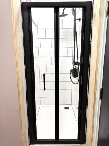 ein Badezimmer mit Dusche mit Glastür in der Unterkunft Beautiful En-suite room by Hostara Homes in London