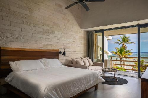 a bedroom with a bed and a view of the ocean at Villa Azanik in Tulum