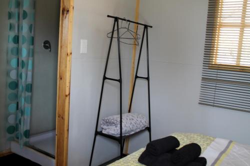 a room with a ladder and a chair and a bed at Thirty-Three Dinokeng Big 5 in Klipdrift