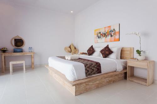 a bedroom with a large bed with a wooden frame at Maisaba Seminyak Loft & Villas in Seminyak