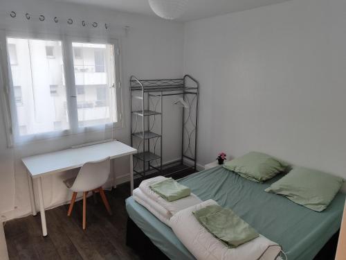- une chambre avec un lit et un bureau dans l'établissement Séjours des Rossignols, à Tours