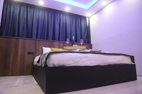 a bedroom with a large bed with a blue curtain at Del Mare Park in Kérynia
