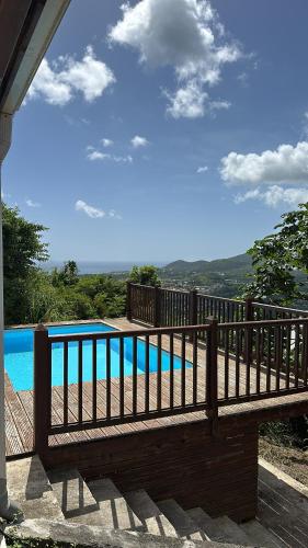 a wooden fence next to a swimming pool at Villa Jamora in Rivière-Pilote