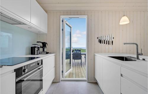 a white kitchen with a view of a deck at Nice Home In Kalundborg With Wifi in Kalundborg