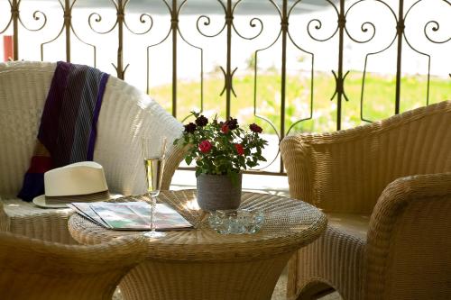 a table with a vase of flowers and a wine glass at Hôtel Beau Site in Malbuisson