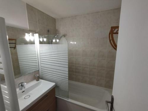 a bathroom with a sink and a tub and a mirror at Appartement 4 personnes entre mer et Golf à Anglet in Anglet