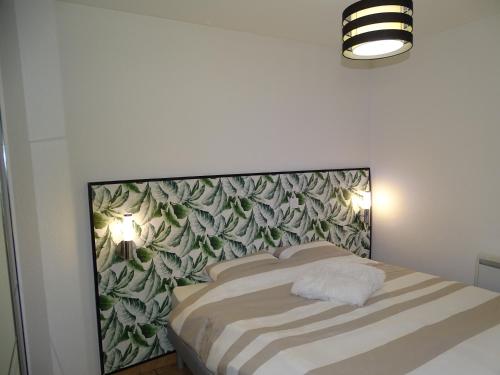 a bedroom with a bed with a green wall at Appartement 4 personnes entre mer et Golf à Anglet in Anglet