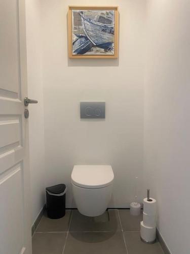 une salle de bain avec toilettes et un tableau au mur dans l'établissement Villa Florebo 3 chambres Confort, Calme et Charme, à Gujan-Mestras