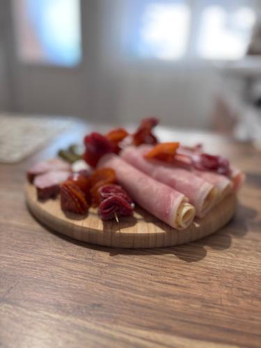 a plate of bacon and other meats on a table at Tiny Studio Universitate in Craiova