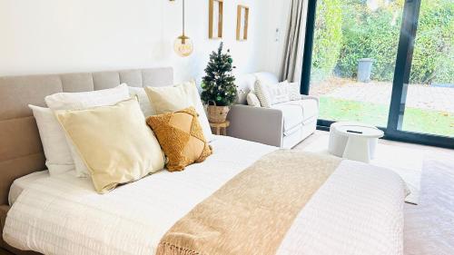 Dormitorio con cama con almohadas y árbol de Navidad en MY Cabane -POOL HOUSE avec Sauna privée près de Bruxelles, en Oppem