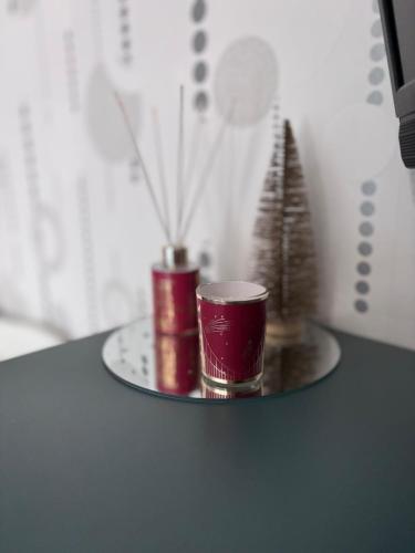 two red cups on a tray with a christmas tree at Tiny Studio Universitate in Craiova