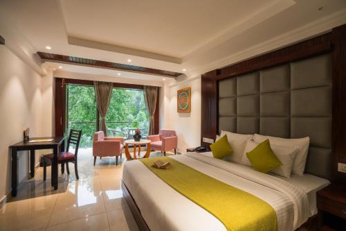 a bedroom with a large bed and a table and chairs at Alt Life Luxe - Himalayan Crown - Dharamkot Mcleodganj in Dharamshala