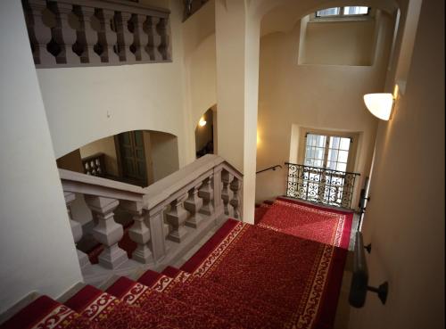 a stairway with a red carpet and a mirror at Schloss Oppurg in Oppurg