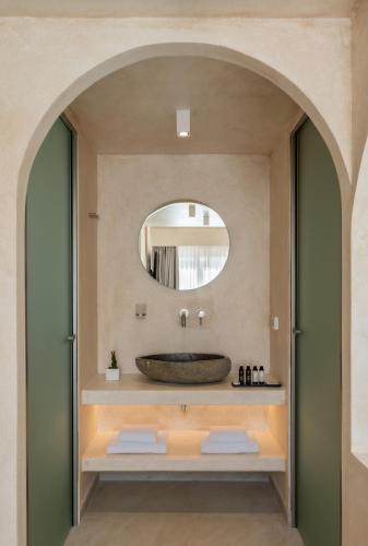 a bathroom with a sink and a mirror at Heyday Luxury Suites in Perissa