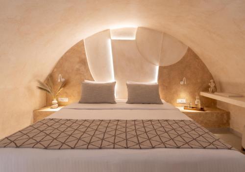 a bedroom with a bed with an arched ceiling at Heyday Luxury Suites in Perissa