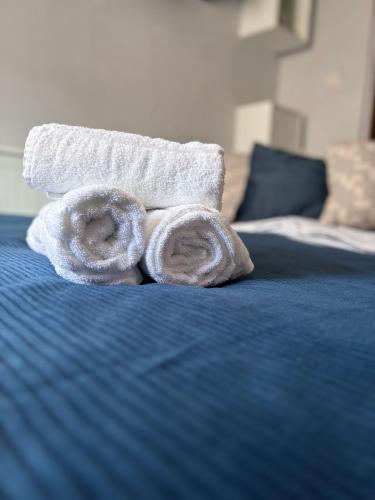 a pile of towels sitting on top of a bed at Tiny Studio Universitate in Craiova