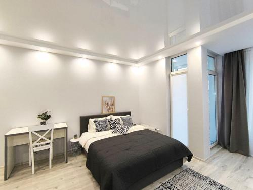 a bedroom with a bed and a desk and a window at Смарт квартира в ЖК Комфорт Таун in Kyiv