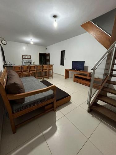 a bedroom with a bed and a living room at Por do sol Boiçucanga in São Sebastião