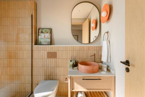 a bathroom with a toilet and a mirror at Kerami Kefalonia in Kefallonia