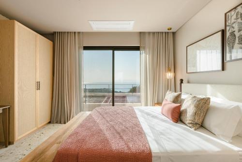 a bedroom with a large bed and a large window at Kerami Kefalonia in Kefallonia