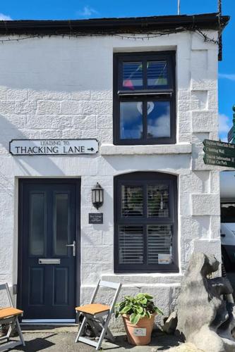a white brick building with a black door and windows at Bear Cottage Cosy little place in the heart Ingleton in Ingleton