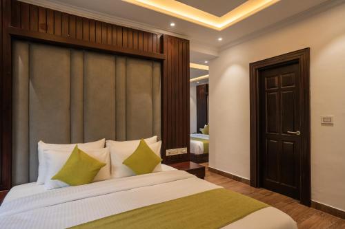 a bedroom with a large bed with green pillows at Alt Life Luxe - Himalayan Crown - Dharamkot Mcleodganj in Dharamshala