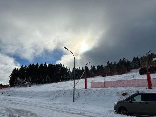 a car parked on the side of a snow covered road at Charmant studio au cœur d une station des Vosges in Sondernach