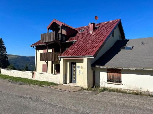 a house with a red roof on the side of a street at Charmant studio au cœur d une station des Vosges in Sondernach