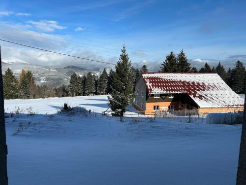 a barn with a snow covered roof in a field at Charmant studio au cœur d une station des Vosges in Sondernach