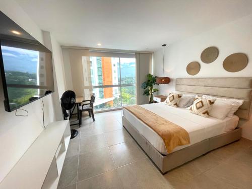 a bedroom with a large bed and a large window at Belmonte502-Apartaestudio en zona exclusiva con piscina in Armenia