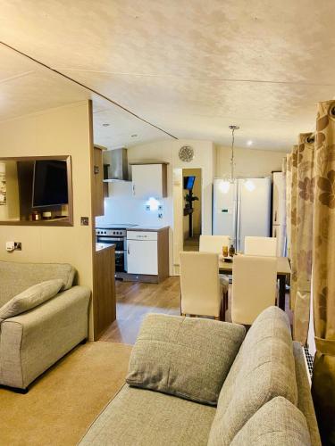 a living room with a couch and a dining room at Lakeside mini lodge in Saint Osyth