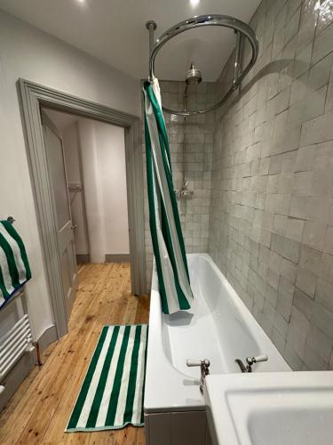 a bathroom with a tub and a sink at 2 bed luxe garden apartment in London