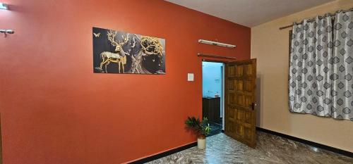a hallway with an orange wall and a door at Charming Goan Home in Old Goa in Old Goa