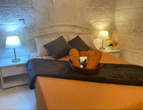 a bed with a basket of pillows on it at Sliema historic townhouse in Sliema