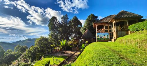 a house on top of a hill with a green field at Agandi Uganda Eco-lodges in Bwindi