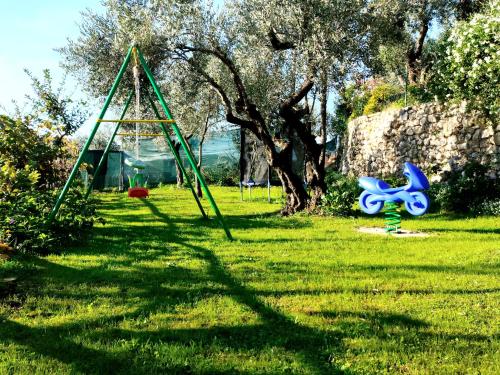 a swing set in the grass with a blue toy at "La casetta" indipendente, con ampio spazio verde in Fontechiari