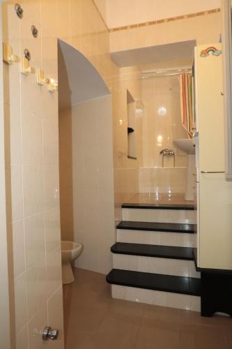 a bathroom with a staircase leading up to a toilet at casa margherita in Pieve di Teco