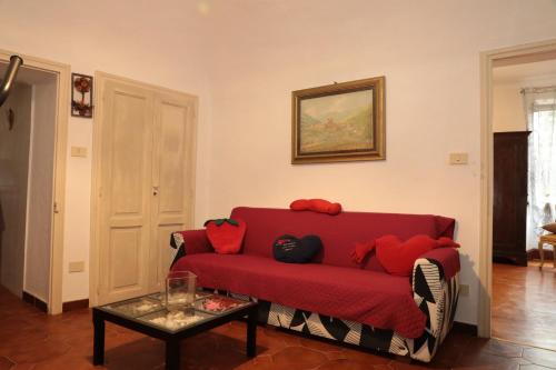 a living room with a red couch and a table at casa margherita in Pieve di Teco