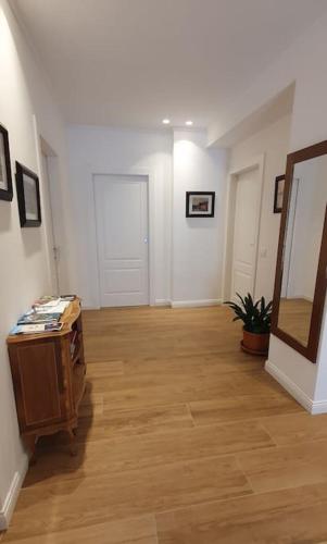an empty room with a wooden floor and white walls at Living with style between mountains & apple orchards in Tuenno