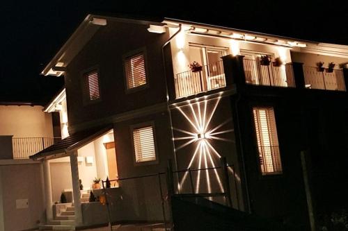 a house with lights on the side of it at night at Living with style between mountains & apple orchards in Tuenno