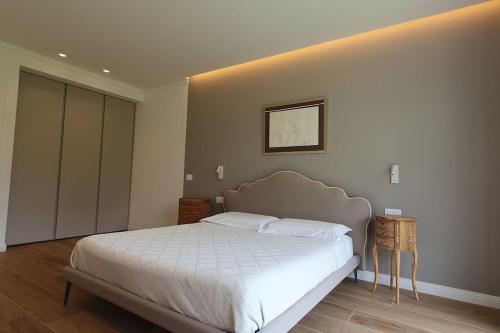 a bedroom with a large white bed in a room at Living with style between mountains & apple orchards in Tuenno