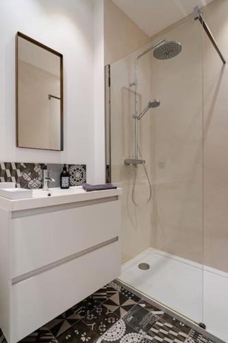 une salle de bain avec une douche, un lavabo et un miroir dans l'établissement Une casa chic Vallon des auffes, à Marseille